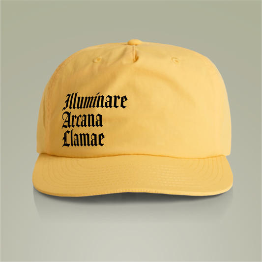 Yellow Illuminare Arcana Lamae Surf Cap with embroidered white llama logo and intricate 'Illuminare Arcana Lamae' lettering, made from 100% recycled nylon with a plastic snapback closure.